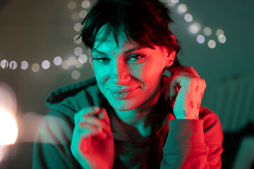Young person smiling with vibrant red green light