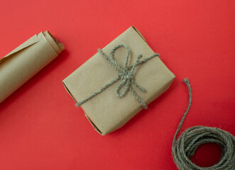 Packing of New Year's gifts Gift, twine, paper on a red background.