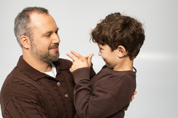 Joyful moments between a father and his little son during a playful indoor session