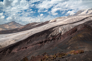 Mountain landscape with glacier and snow-covered peaks under blue sky