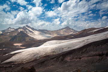 Obraz premium Mountain landscape with glacier and snow-covered peaks under blue sky