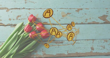 Laying bouquet of pink tulips on distressed turquoise planks, showing gold icon network