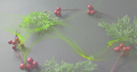 Displaying wreath of evergreen sprigs and red berries on gray tabletop, showing green particle wave