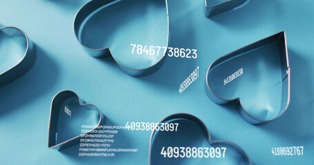 Displaying cluster of metal heart cookie cutters resting on blue tabletop, with white labels © vectorfusionart