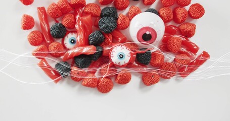 Showing top-down candy on white table, raspberry or blackberry, licorice, 3 eyeballs, dotted-wave © vectorfusionart