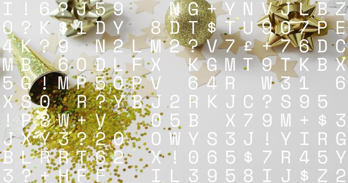 Naklejki Spilling gold popper confetti and glitter on white table, showing bows, ribbon, stars, text overlay