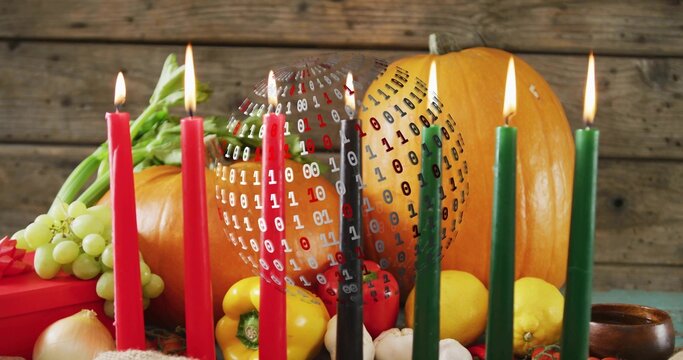 Fototapeta Displaying pumpkin center glowing on teal cloth on wooden table, with lit candles and binary sphere