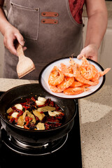 Chef Cooking Fresh Shrimp with Spicy Chinese Seasonings in Traditional Wok - Asian Seafood Cuisine Preparation
