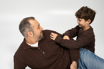 Father and son sharing joyful moments while laughing and playing together at home