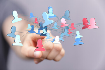 Abstract image showing network of people connected to each other with a hand reaching out to select someone or make a connection within the soci