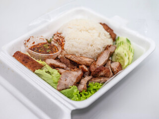 Grilled pork neck with rice and spicy Thai dipping sauce presented in a flavorful, appetizing style