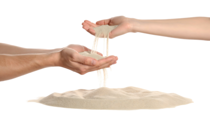 Two hands pouring sand into an open palm below, with a pile of sand in foreground