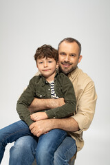 Father enjoys a joyful moment with his little son in a warm embrace at home