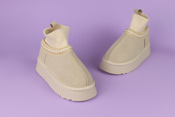 Beige Suede Ankle Boots with Ribbed Socks on Pastel Purple Background for Fashion Display