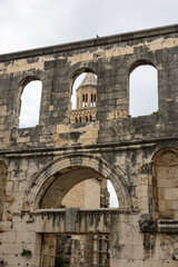 Ancient Stone Ruins With Arched Windows And Tower Seen Through A Weathered Archway, Diocletian's Palace, Split, Croatia