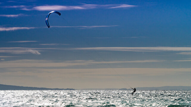 Kite surfer riding waves. Kiteboarding sport.