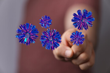 An artistic representation of digital virus concept floating in front of human hand in dark background. Concep
