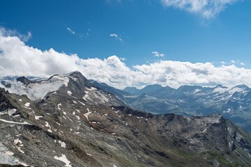 A stunning alpine landscape featuring majestic mountains covered in snow and glaciers. The vibrant blue sky enhances the scene, ideal for travel, adventure, or scenic backgrounds.
