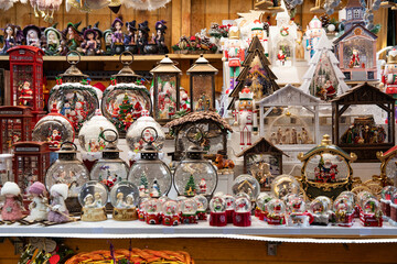 huge selection of traditional christmas souvenirs and snow globes on the stall of a festive bazaar