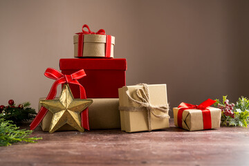 Festive Christmas craft gift boxes with red bows on wooden background