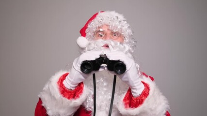 Santa claus looking through binoculars finding good children