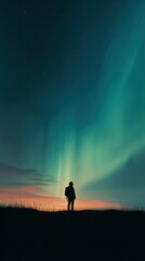 Fototapeta premium Vertical Portrait of Solitary Person Silhouette Standing Under Dramatic Green Aurora Borealis and Starry Night Sky