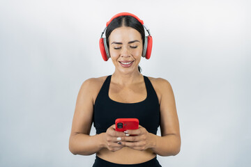 Healthy woman listening music on headphones and using cell phone