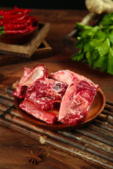 Fresh Raw Beef Ribs on Wooden Plate with Herbs