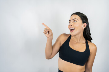 Young healthy mexican woman pointing, smiling, advertising copy space