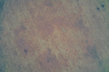 Aerial top down view of untilled field texture with small shell craters. War zone agricultural land background. Rust colored dry grass pattern.
