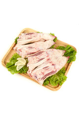 Raw Pork Trotters on Wooden Board with Fresh Greens and Lemon