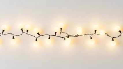 A string of lights with round bulbs hanging against a plain light background creating a warm glow effect