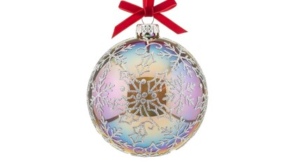 Iridescent christmas ornament with silver snowflakes and red bow on a white background close up