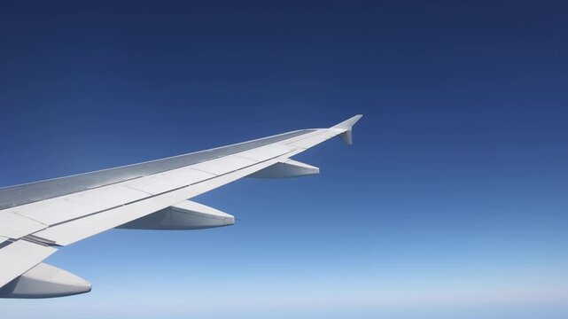 airplane flying through clouds view from plane window of aircraft in flight (commercial aviation engine wing) travel tourism