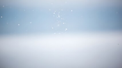 A soft blue and white background with small blurry particles scattered in the upper half area