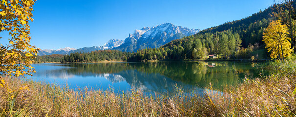 Karwendel alps and hut reflecting in the water of lake Lautersee, autumn scene near Mittenwald