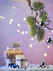 Christmas and New Year greeting card. Gift delivery concept. A toy truck carries a gift box , copy space