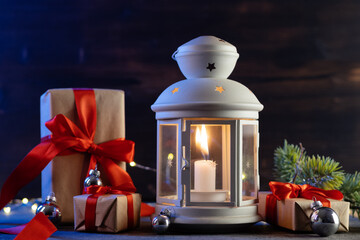 Christmas lantern with red gift boxes on the table