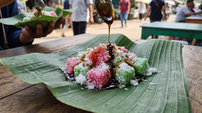 Macro close up of colorful Indonesian traditional snack Cenil with grated coconut and liquid palm sugar