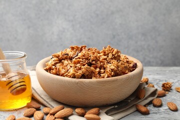 Tasty granola with dried fruits and honey on light grey table, closeup
