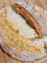 Bread on a wooden board Homemade baked bread on sourdough made of half flour lies on a wooden board close-up. Healthy nutrition.