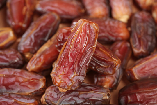 Golden dried dates fruits close-up - healthy natural sweet snack food ingredients