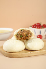Handmade Steamed Pork Buns with Scallion Filling on Wooden Board - Traditional Asian Cuisine