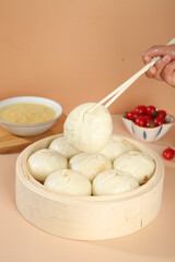Handmade Pork and Scallion Steamed Buns in Bamboo Steamer with Chopsticks - Traditional Asian Dim Sum