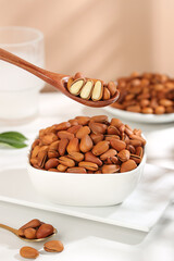 Handpeeled Red Pine Nuts in Bowl with Wooden Spoon - Large Northeast Nuts Food Ingredient