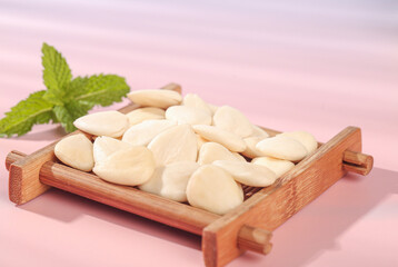 Peeled Almond Slices with Mint in Wooden Tray on Pink Background - Healthy Cooking Ingredient