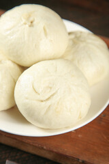 Fresh Handmade Pork and Scallion Steamed Buns on White Plate
