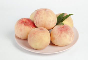 Fresh Yangshan Peaches from Wuxi China on White Plate with Leaves