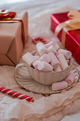 Close Up Side View of Mug with Marshmallows and Gift Boxes in Background