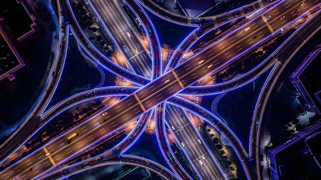 Aerial Night View of Illuminated Highway Interchange with Converging Roads and Lights